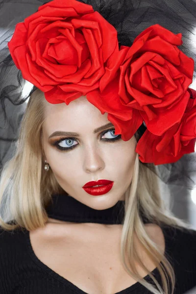 Parlak makyajlı çekici gotik kadın harika bir başlık takıyor ve kameraya bakıyor.