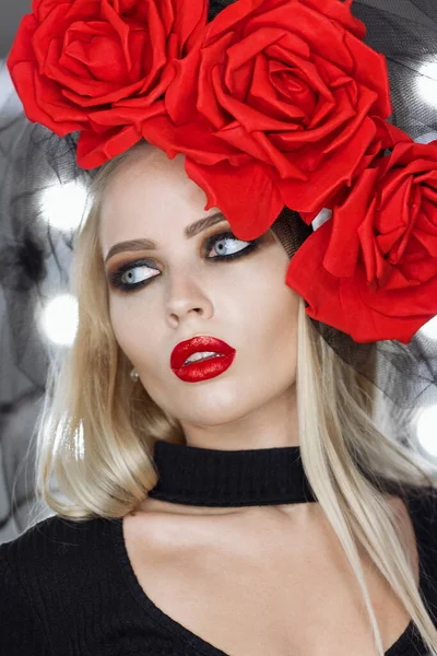 Parlak makyajlı çekici gotik kadın harika bir başlık takıyor ve kameraya bakıyor.