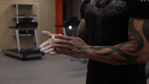 Un bodybuilder se frotte les mains avec de la poudre de talc — Video