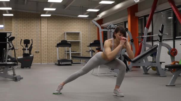 Sportieve vrouw opwarmen en trainen in de sportschool — Stockvideo