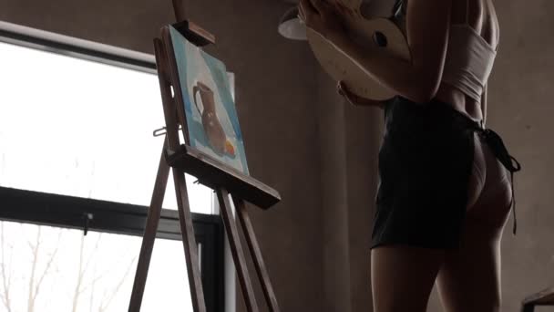 Mujer pintando sobre caballete en taller — Vídeos de Stock