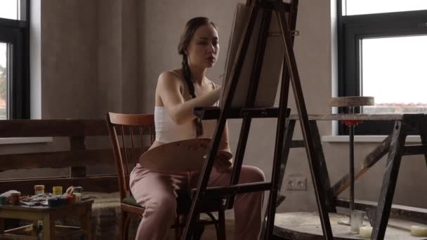 Calme femme peinture dans la lumière home studio — Video