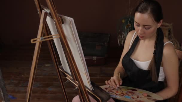 Ruhige Frau malt im hellen heimischen Atelier — Stockvideo