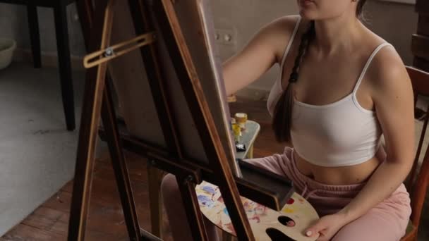 Спокійна жінка малює в світлій домашній студії — стокове відео