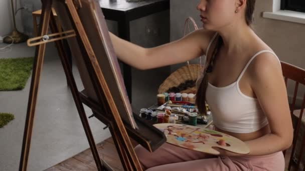 Calma mujer pintura en casa estudio de luz — Vídeo de stock