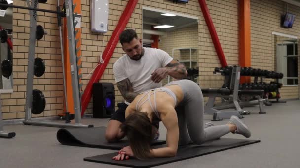 Sportlerin trainiert mit persönlichem Trainer im Fitnessstudio — Stockvideo
