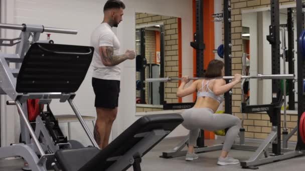 Sportvrouw training met persoonlijke instructeur in de sportschool — Stockvideo