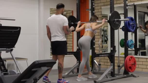 Sportlerin trainiert mit persönlichem Trainer im Fitnessstudio — Stockvideo