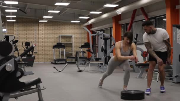 Sportlerin trainiert mit persönlichem Trainer im Fitnessstudio — Stockvideo