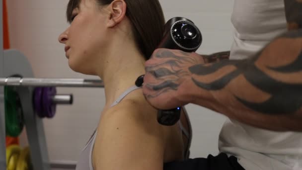 Entraîneur personnel étirant les jambes de la sportive dans la salle de gym — Video