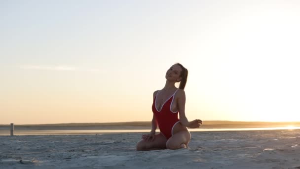 Slim kobieta w sexy strój kąpielowy na wybrzeżu o zachodzie słońca — Wideo stockowe