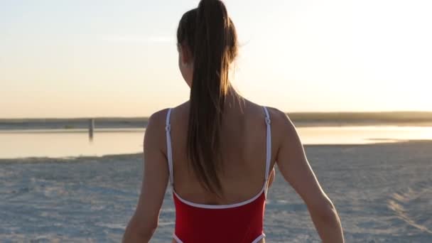 Sexy Frau im Badeanzug am Strand bei Sonnenuntergang — Stockvideo