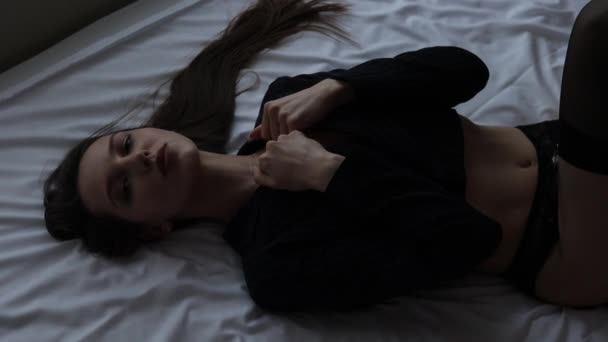 Чувственная женщина в эротическом белье на кровати — стоковое видео