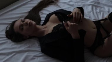 Yatakta erotik iç çamaşırlı şehvetli bir kadın.