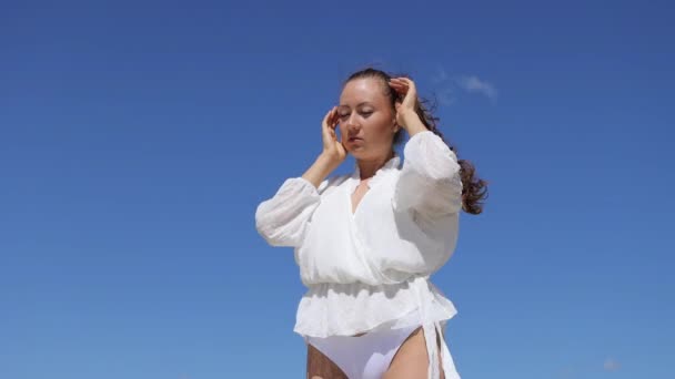 Sinnliche Frau in weißer Kleidung genießt Brise — Stockvideo
