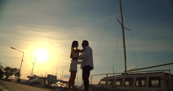 Romantisch koppel met datum op dijk bij zonsondergang — Stockvideo