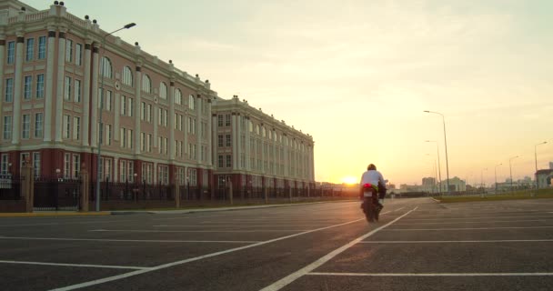 Snygg affärsman med moto scooter på urban gata — Stockvideo