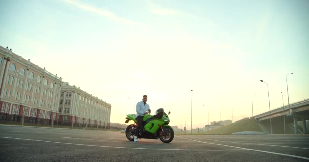 Snygg affärsman med moto scooter på urban gata — Stockvideo