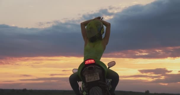 Mujer irreconocible en motocicleta al atardecer — Vídeos de Stock