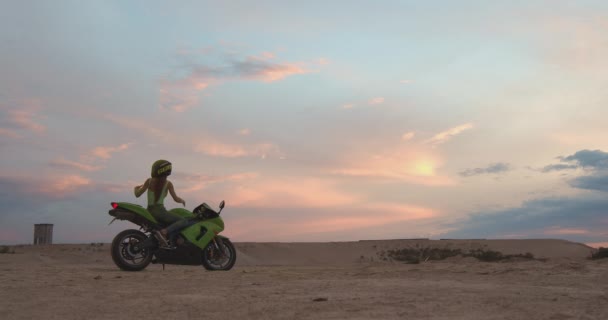 Крутая женщина в шлеме на мотоцикле на пляже — стоковое видео