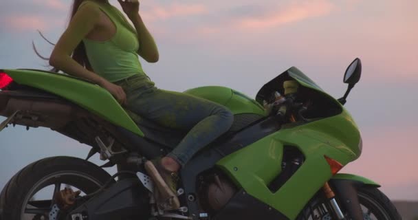 Αγνώριστη γυναίκα με μοτοσικλέτα στο ηλιοβασίλεμα — Αρχείο Βίντεο
