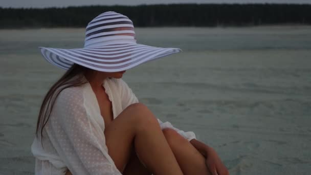 Κομψή γυναίκα στο καπέλο χαλαρώνοντας στην παραλία — Αρχείο Βίντεο