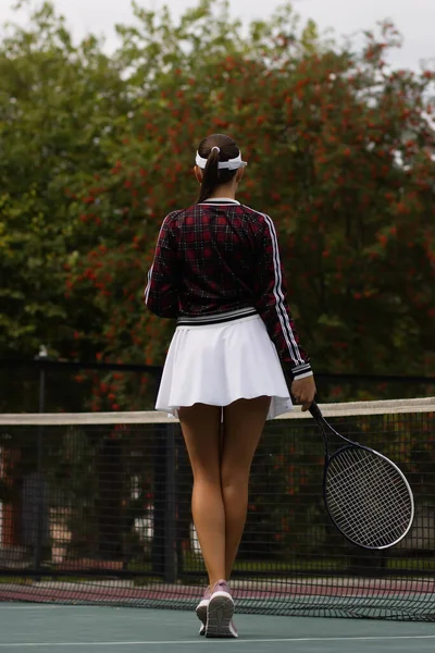 身穿白衣 体形丰满 体形苗条的女子 球拍在阳光灿烂的球场上打网球 — 图库照片