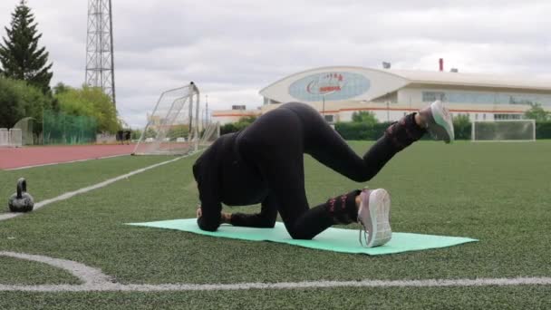 Femme mince gracieuse échauffement au stade de la ville — Video