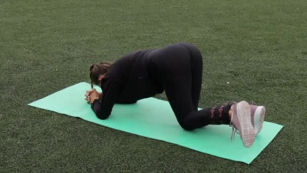 Femme mince gracieuse échauffement au stade de la ville — Video