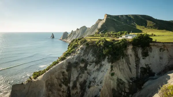 Beyaz Saray, Cape Kidnappers Trail, Yeni Zelanda 'da bulutsuz güneşli bir günde çekilen, arka planda pelerin ve okyanusla birlikte uçuruma inşa edildi.