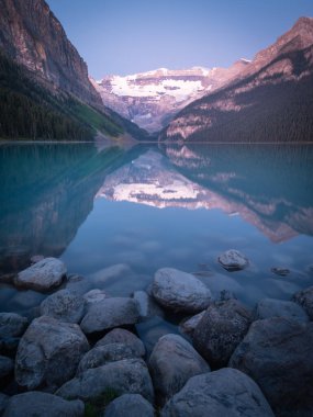 Çevresini yansıtan güzel Alp Gölü 'nün portresi. Louise Gölü, Banff Ulusal Parkı, Kanada' da gündoğumunda çekildi.