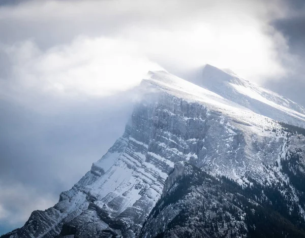 Snowy mountain peak Mount Rundle covered by snow and shrouded by clouds and winds, detailed shot made at Vermilion Lakes, Banff National Park,Canada — Stock Photo, Image