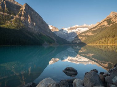 Güzel alp gölü çevresindekileri yansıtıyor. Louise Gölü, Banff Ulusal Parkı, Kanada 'da gündoğumunda çekilmiş.