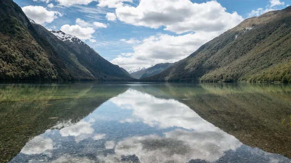 Vackra stilla reflektioner på en sjö under solig dag. Symmetriskt foto taget vid sjön Gunn, Fiordlands nationalpark, Nya Zeeland — Stockfoto