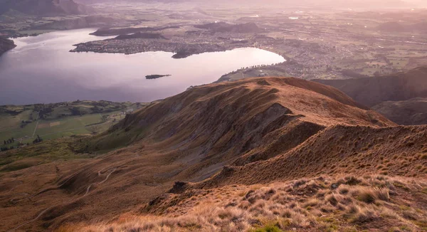 Vista sobre valle con lago al amanecer. Tiro hecho en la cumbre de Roys Peak en Wanaka, Nueva Zelanda — Foto de Stock