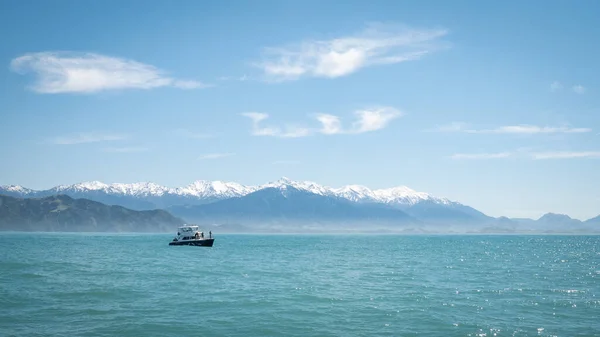 Σκάφος στον ωκεανό με φόντο το βουνό. Πυροβολήθηκε στη χερσόνησο Καϊκούρα της Νέας Ζηλανδίας — Φωτογραφία Αρχείου