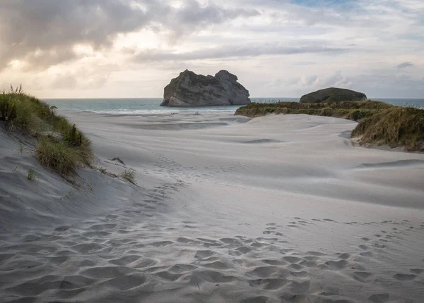 Playa con arena blanca, filmada al atardecer en Wharariki Beach, Nueva Zelanda — Foto de Stock