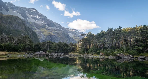 Lago alpino prístino rodeado de árboles y montañas, filmado justo antes del atardecer en el Parque Nacional Nelson Lakes, Nueva Zelanda — Foto de Stock