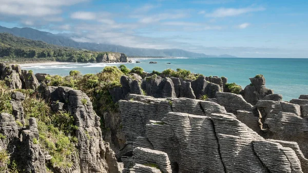 Formaciones rocosas inusuales en la costa de los océanos rodadas durante el día soleado, Foto hecha en Punakaiki Pancake Rocks, Costa Oeste, Nueva Zelanda — Foto de Stock