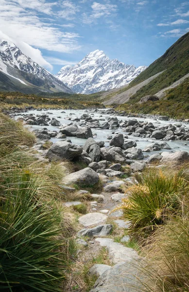 Porträtt bild av glaciär flod som leder till berg i bakgrunden gjort på solig dag. Skjuten i Aoraki Mt Cook National Park, Nya Zeeland — Stockfoto