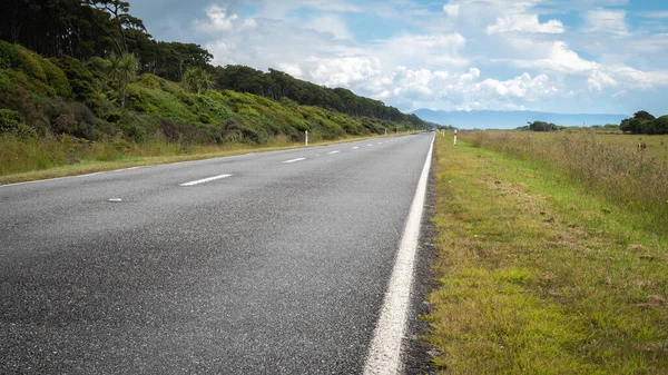 Droga prowadząca do prostego horyzontu odległości. Strzały w słoneczny dzień na zachodnim wybrzeżu Nowej Zelandii — Zdjęcie stockowe