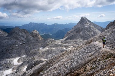 Slovenya 'da kayalık tepeleri ve yaprakları olmayan kuru dağlarda yürüyen yürüyüşçü.