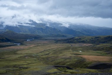 Engebeli İskandinav manzarasında küçük bir ev, arka planda liken ve karlı dağlar, İskoçya, İzlanda.