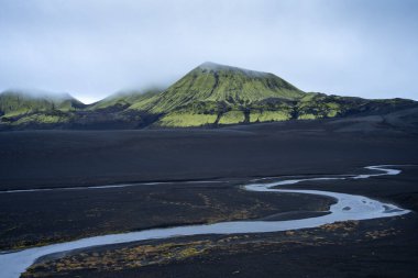 Kara kum ve buzul nehrinin aktığı engebeli volkanik manzara, İskoçya, İzlanda.