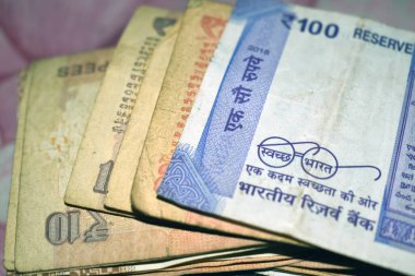 Bir deste yeni ve eski Hindistan parası. 100 rupi, 20 rupi, 10 rupi.