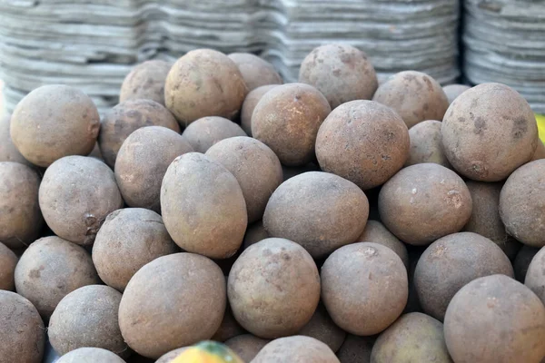 Yerel pazarda bir avuç sapodilla, pazarda Sapodillas 'ın yakın plan bir fotoğrafı.