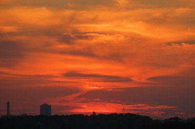 Günbatımını turuncu sarı arka planda koyu bulutlu