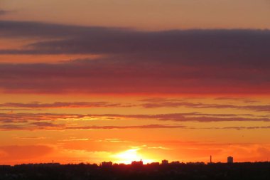 Güzel turuncu bordo gün batımı şehrin üzerinde