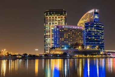 Dubai, Birleşik Arap Emirlikleri - 9 Ağustos 2021: Dubai 'deki Festival Şehri' nin güzel gece manzarası. Hotel Crown Plaza ve otelin kıtalararası binaları görünüyor..