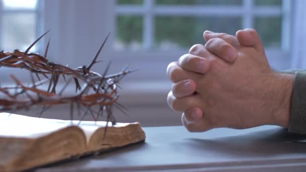 聖書ととげの冠の横で手で祈る男 — ストック動画